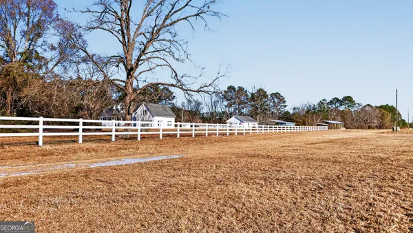 a front view of house with yard and trees around