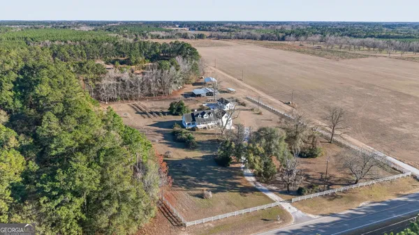 an empty room with a window and a chandelier fan