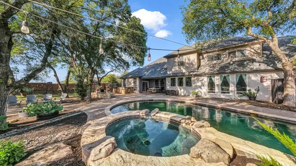 a view of a house with pool fire pit tables and chairs