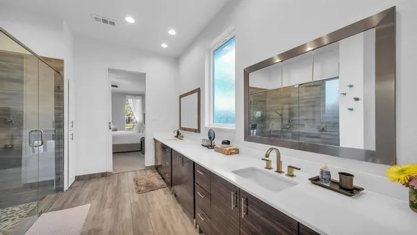a bathroom with a double vanity sink a mirror and shower