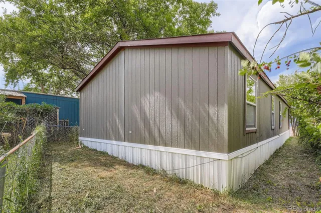 a view of a house with a small yard and wooden fence