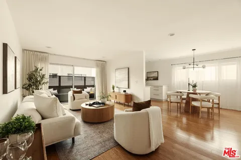a living room with furniture wooden floor and a large window