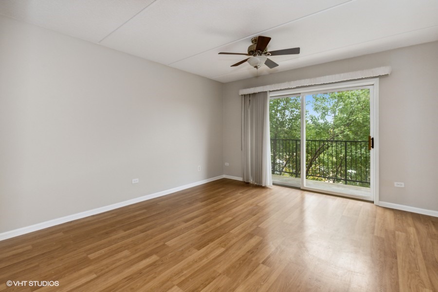 351 Town Pl Circle, Unit 405 Buffalo Grove, IL 60089 - Photo 4 of 13 a view of room with window ceiling fan and hardwood floor