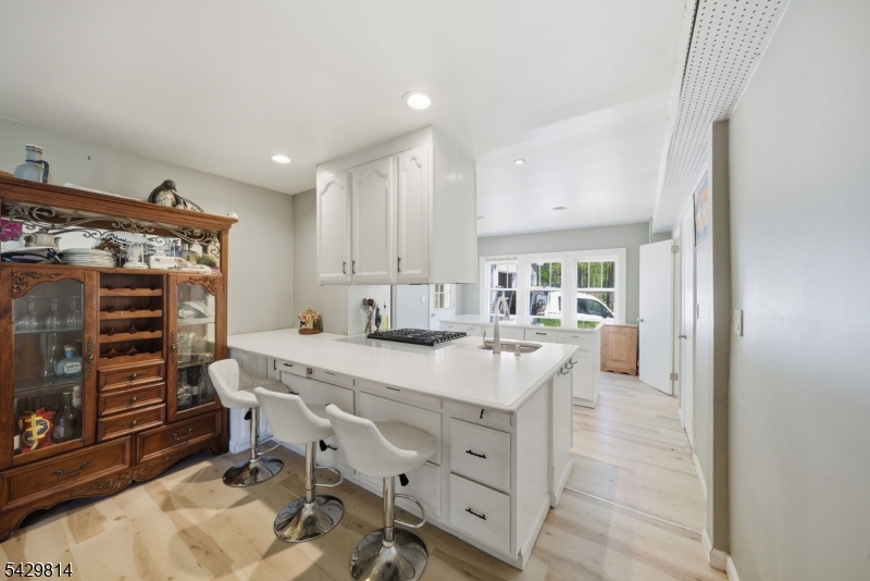251 Russia Road Oak Ridge, NJ 07438 - Photo 7 of 34 a kitchen with a table chairs refrigerator and cabinets