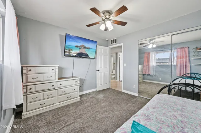 a spacious bedroom with a bed and a chandelier