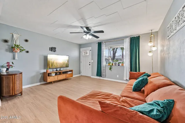 a dining room with furniture potted plants and wooden floor