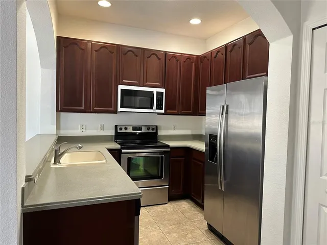 a kitchen with wooden cabinets and stainless steel appliances