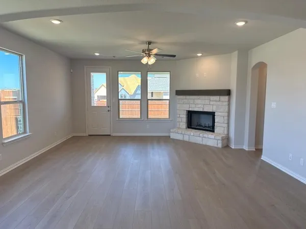an empty room with windows and fireplace