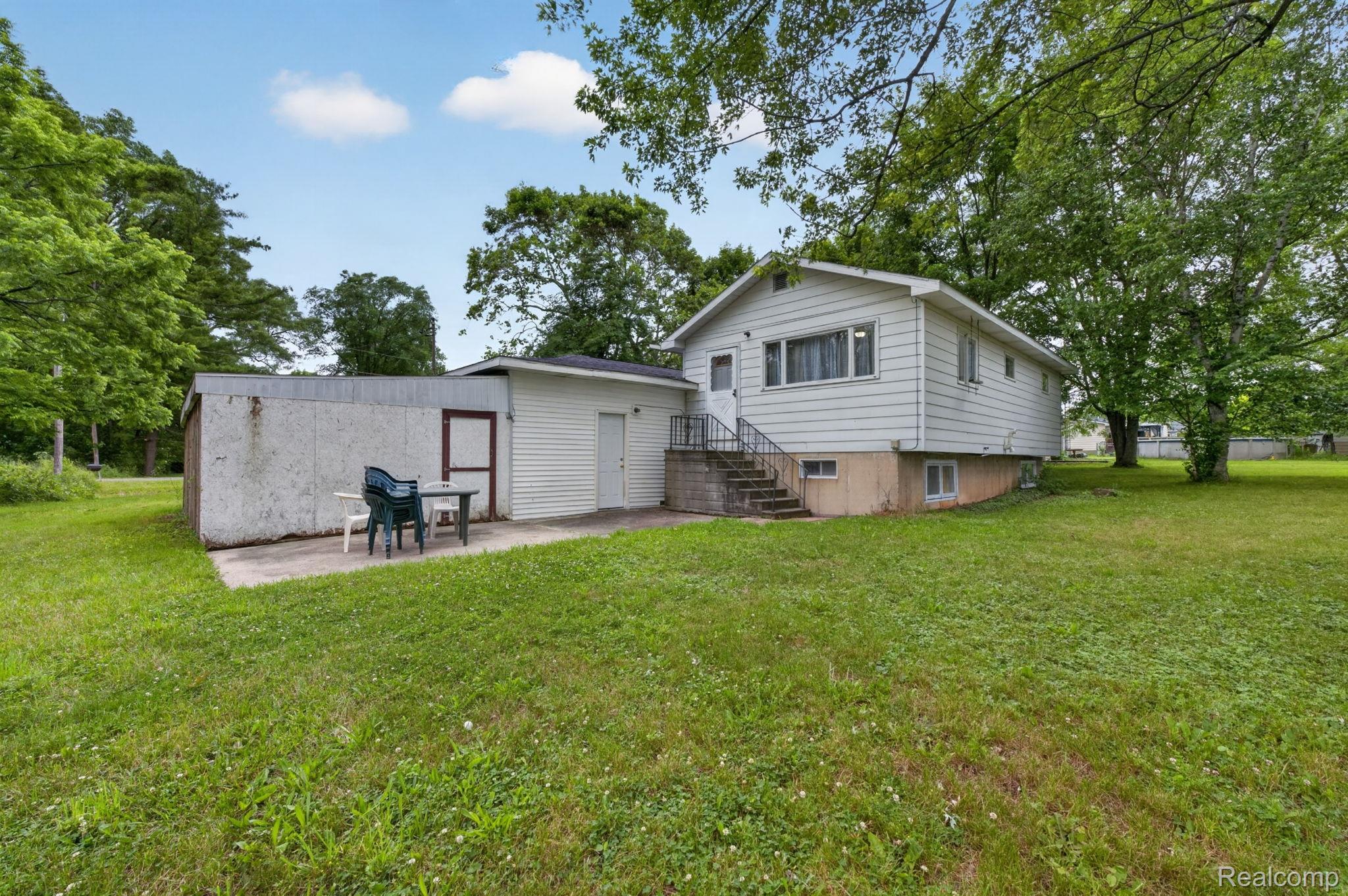 9288 Hilda Lane Flushing, MI 48433 - Photo 39 of 50 Expansive green lawn with mature trees and a concrete patio