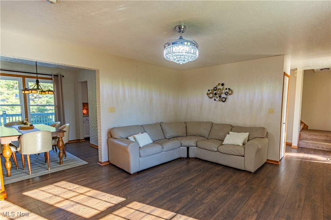 2121 South Cleveland Massillon Road Akron, OH 44321 - Photo 5 of 26 Living room featuring dark wood-type flooring, a notable chandelier, and a textured ceiling