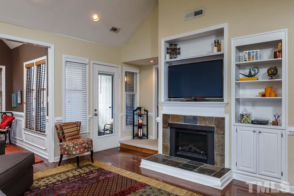 241 New Bern Place, Unit 301 Raleigh, NC 27601 - Photo 1 of 25 a living room with furniture a flat screen tv and a fireplace
