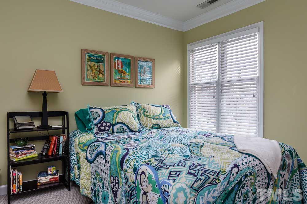 241 New Bern Place, Unit 301 Raleigh, NC 27601 - Photo 14 of 25 a bedroom with a bed and a lamp