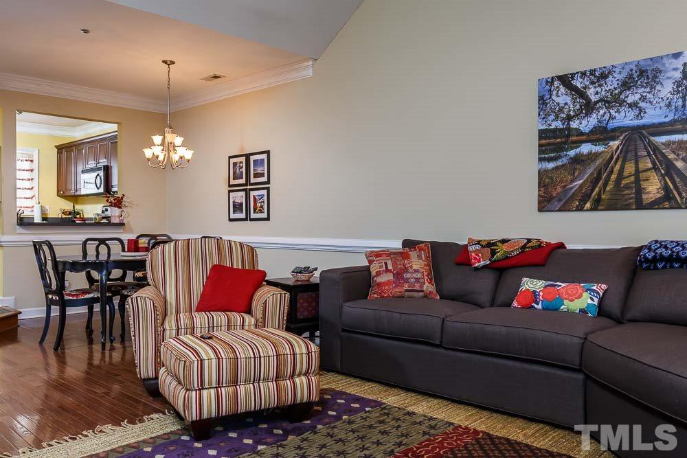 241 New Bern Place, Unit 301 Raleigh, NC 27601 - Photo 3 of 25 a living room with furniture a rug and a chandelier