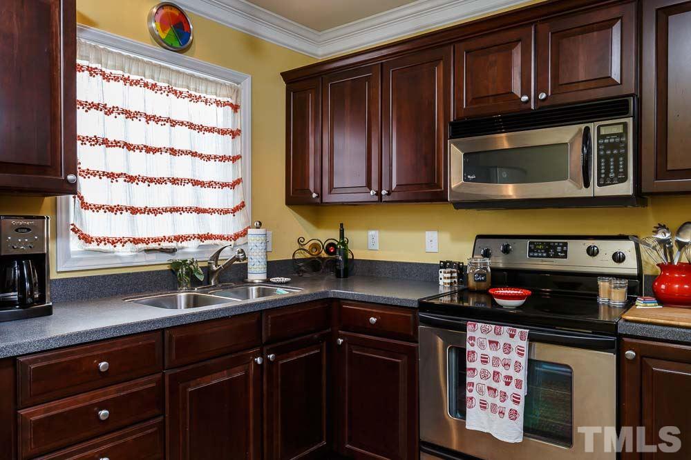241 New Bern Place, Unit 301 Raleigh, NC 27601 - Photo 5 of 25 a kitchen with stainless steel appliances granite countertop a stove a sink and a microwave