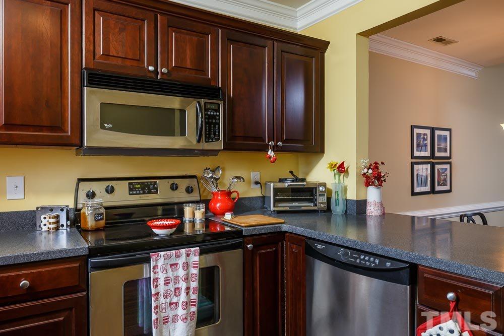 241 New Bern Place, Unit 301 Raleigh, NC 27601 - Photo 6 of 25 a kitchen with stainless steel appliances granite countertop a stove and cabinets