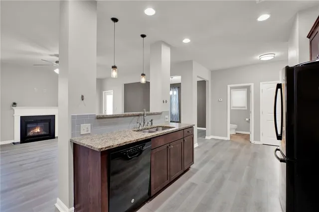 a view of an empty room with kitchen appliances and a ceiling fan