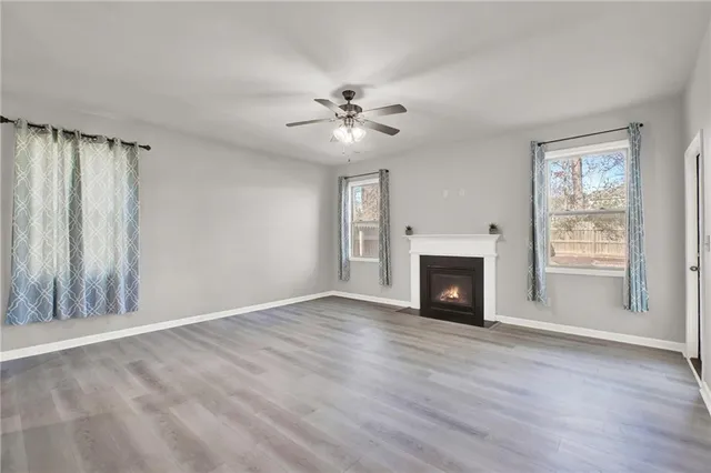 a view of an empty room with window and wooden floor