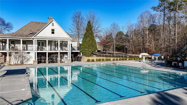 a view of a swimming pool with a patio and fire pit