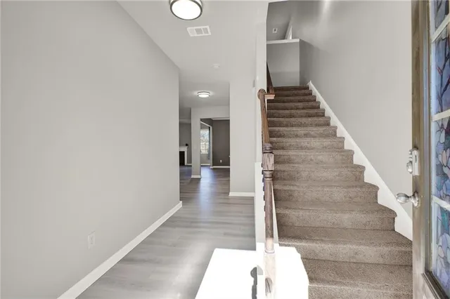 a view of a hallway with wooden floor and entryway