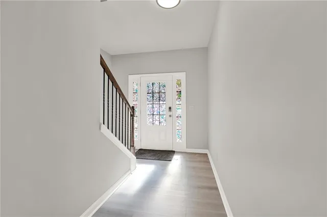 a kitchen with stainless steel appliances granite countertop a refrigerator a sink dishwasher and a oven with white cabinets