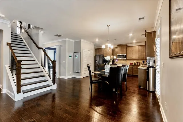 a view of a dining room and livingroom with furniture wooden floor a rug and a kitchen