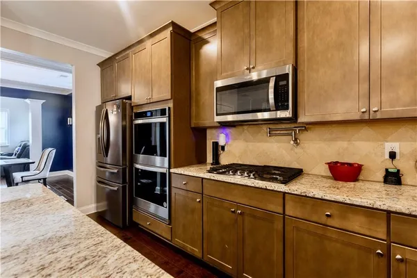 a kitchen with stainless steel appliances granite countertop a refrigerator stove and microwave