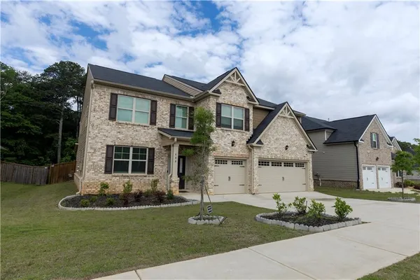 a front view of a house with a garden and plants