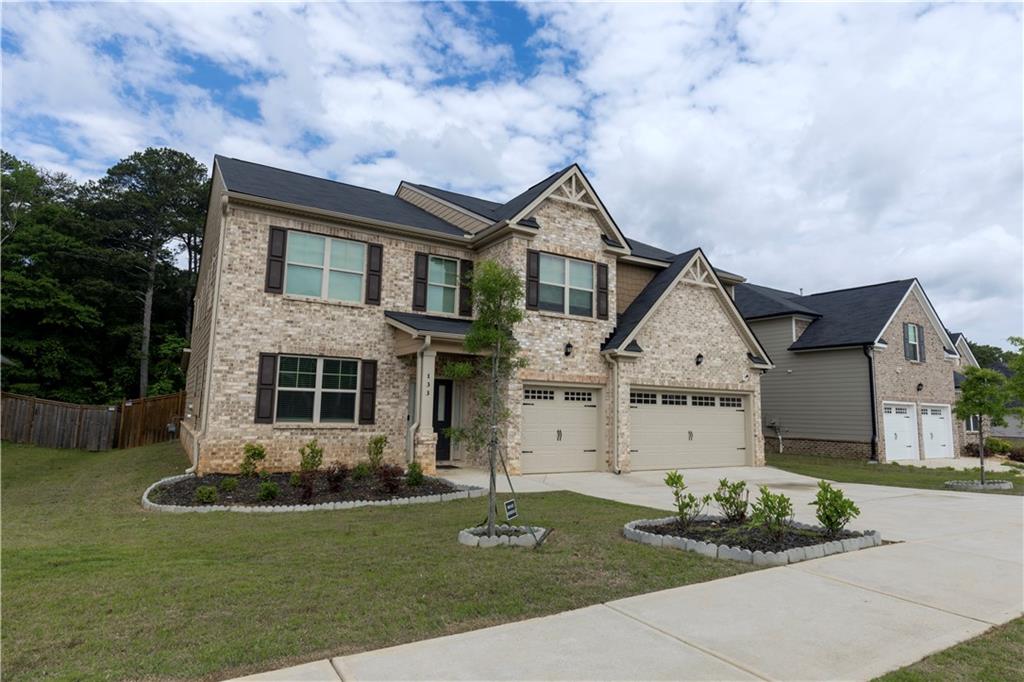 133 Canal Street Hampton, GA 30228 - Photo 2 of 43 a front view of a house with a garden and plants