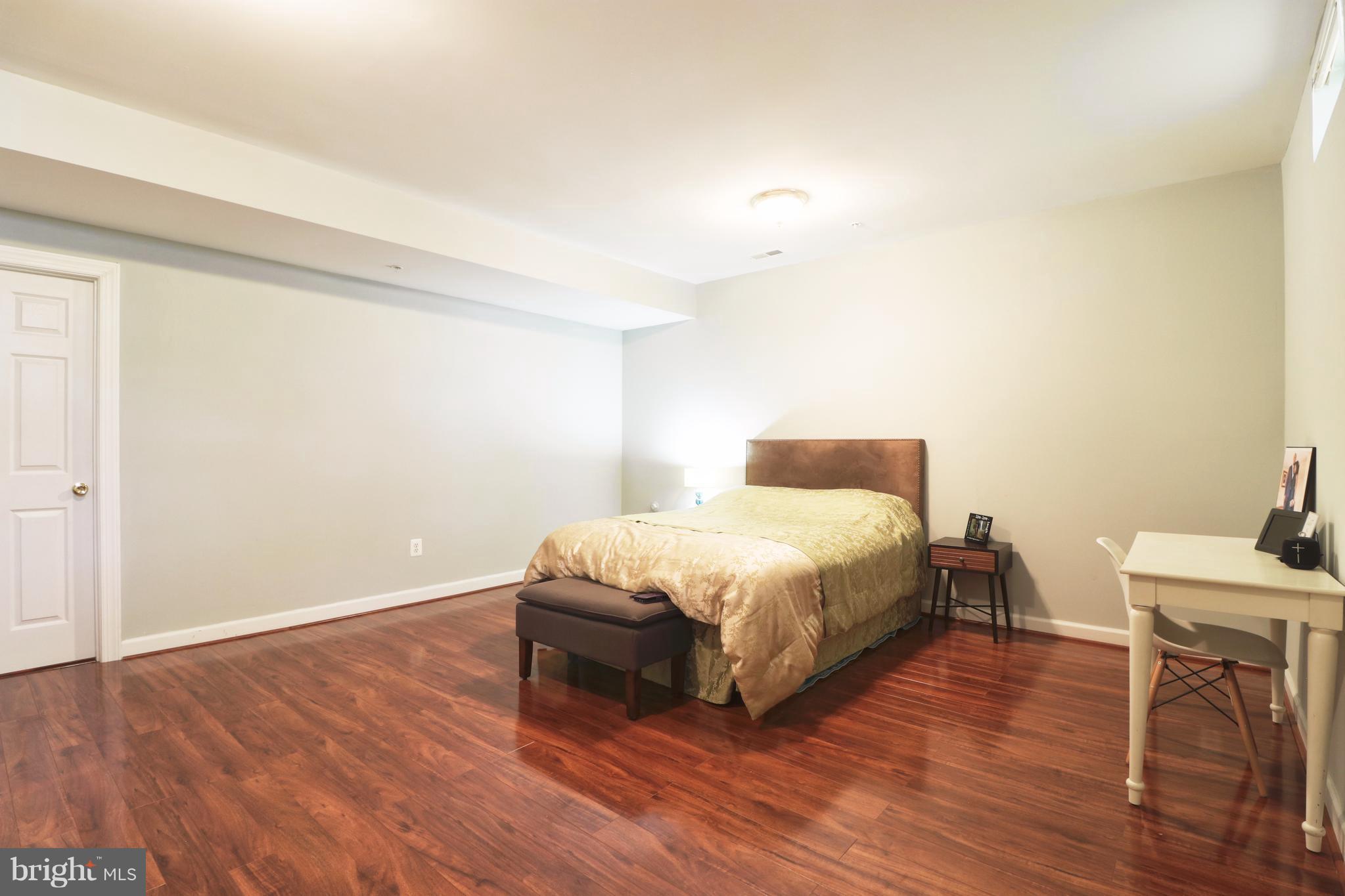 14406 Dunstable Court Bowie, MD 20721 - Photo 26 of 30 a spacious bedroom with a bed and a table in it