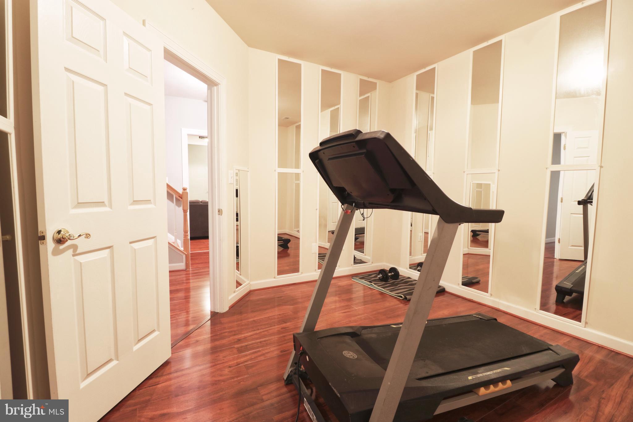 14406 Dunstable Court Bowie, MD 20721 - Photo 27 of 30 a room with gym equipment and wooden floor