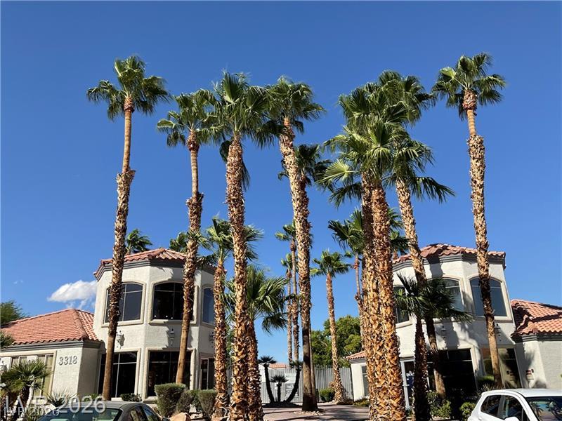3318 North Decatur Boulevard, Unit 2152 Las Vegas, NV 89130 - Photo 34 of 58 Lush palms frame this multi-story building under a clear blue sky.