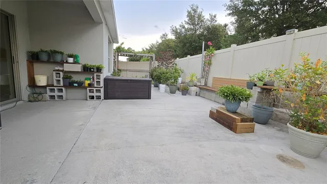 a view of a patio with plants and chairs