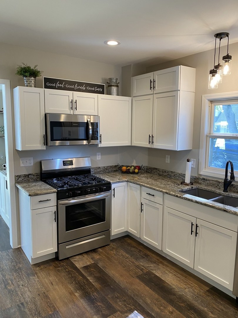 430 South 1st Street DeKalb, IL 60115 - Photo 11 of 34 a kitchen with stainless steel appliances white cabinets a stove a sink and a microwave