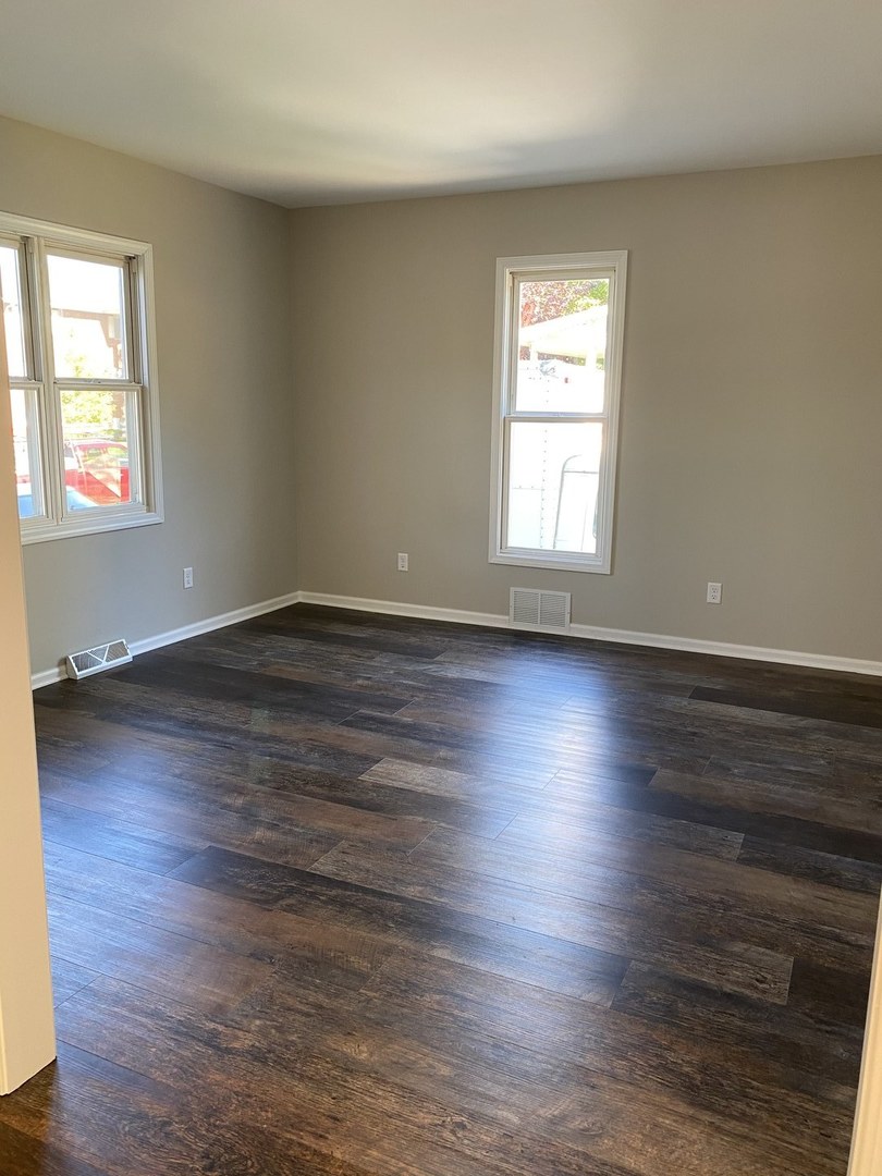 430 South 1st Street DeKalb, IL 60115 - Photo 13 of 34 an empty room with wooden floor and windows