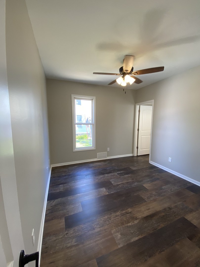 430 South 1st Street DeKalb, IL 60115 - Photo 14 of 34 an empty room with wooden floor ceiling fan and window