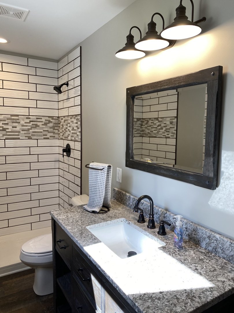 430 South 1st Street DeKalb, IL 60115 - Photo 17 of 34 a bathroom with a granite countertop sink toilet and mirror