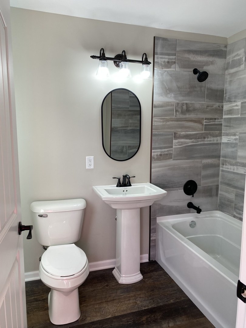 430 South 1st Street DeKalb, IL 60115 - Photo 26 of 34 a bathroom with a toilet a sink and a bathtub