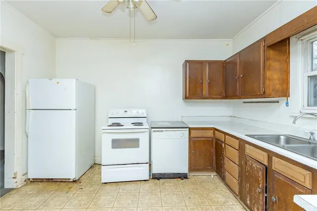a kitchen with a sink a refrigerator and cabinets