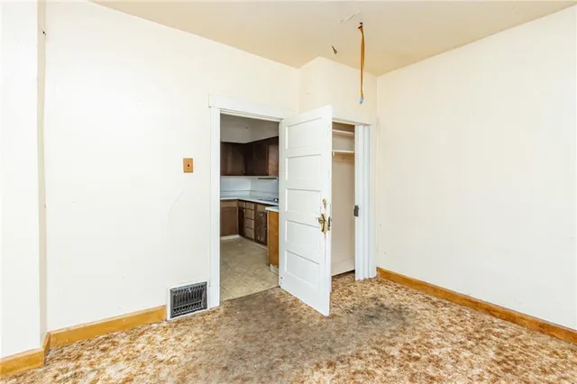 a view of a room with wooden floor and a hallway