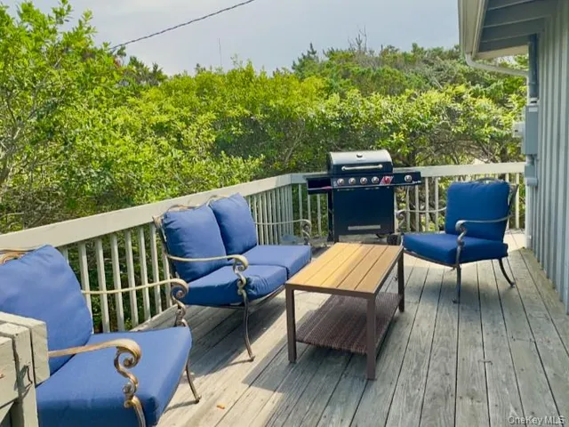 a balcony with wooden floor and outdoor seating