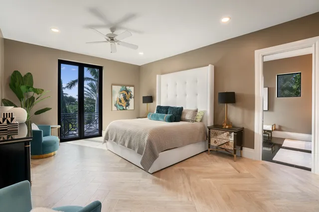 a view of a white house with a big yard and palm trees