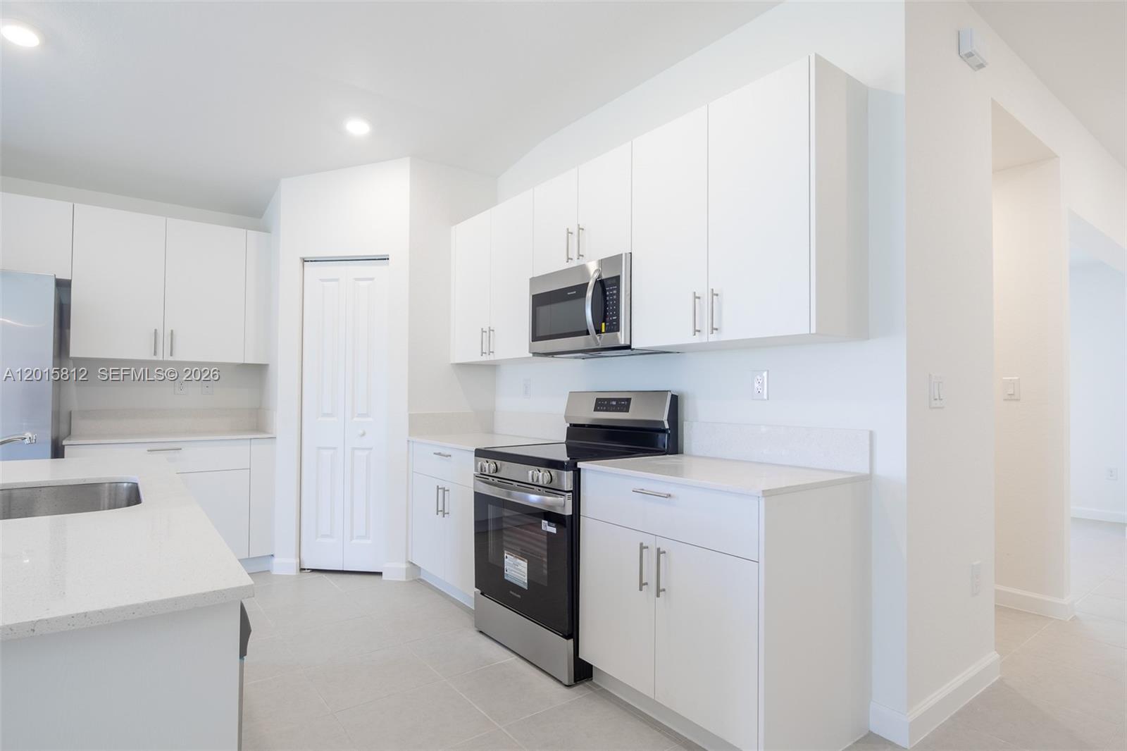 17564 Southwest 285th Street Homestead, FL 33030 - Photo 7 of 42 a kitchen with white cabinets and stainless steel appliances