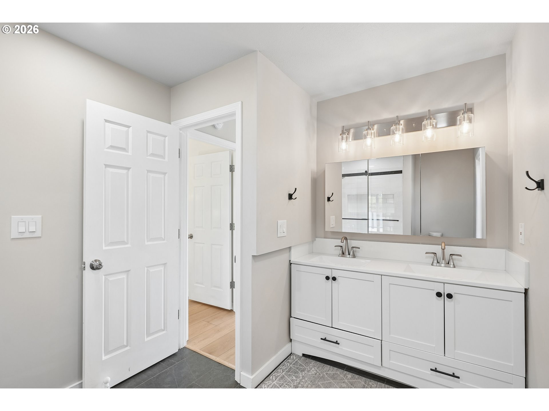 14936 Northwest Mill Road, Unit K Portland, OR 97231 - Photo 20 of 33 a bathroom with a double vanity sink a mirror and a bathtub