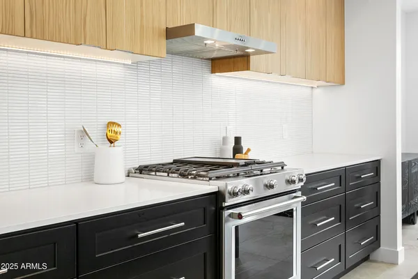 a kitchen with a sink and a stove with wooden floor