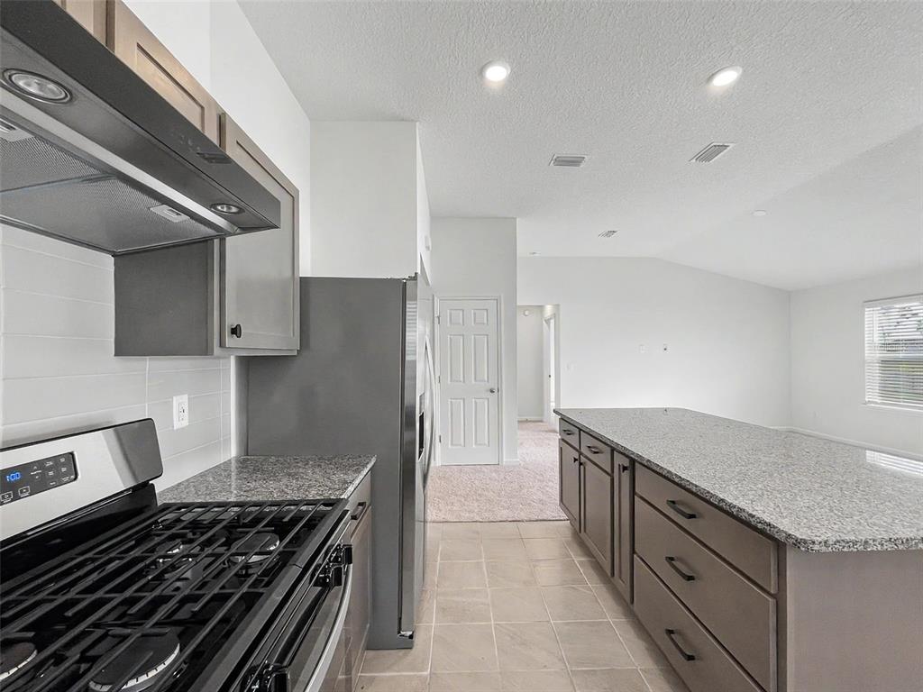 55 Signet Circle Flagler Beach, FL 32136 - Photo 23 of 39 a kitchen with granite countertop a stove and a sink