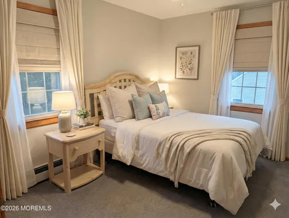 a bedroom with a bed a table and painting on the wall