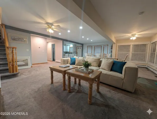 a living room with furniture a large window and a chandelier
