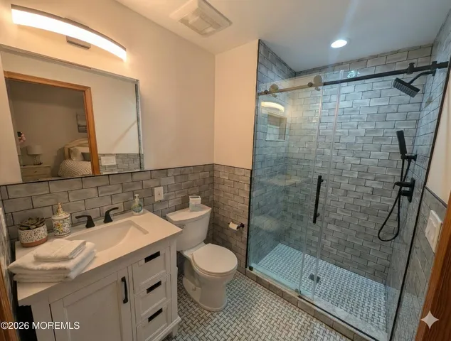 a bathroom with a sink a toilet and shower