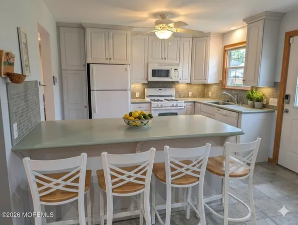 a kitchen with granite countertop white cabinets and stainless steel appliances