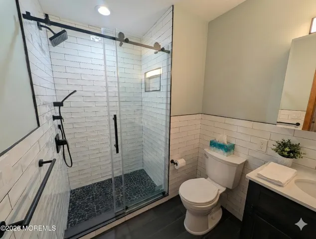 a bathroom with a shower toilet and sink